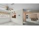 Bright living room featuring a ceiling fan, light gray floors, and view of the kitchen and adjacent living area at 13000 Club Dr, Hudson, FL 34667