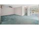 Spacious room featuring a ceiling fan, carpet, and access to sun room at 13000 Club Dr, Hudson, FL 34667
