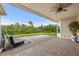 Comfortable covered patio with fan offers a relaxing outdoor space with lush landscaping at 30715 Tumbleberry St, Wesley Chapel, FL 33543