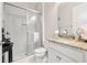 Bathroom featuring a tiled shower with glass door, white vanity, and granite countertop with designer hardware at 30715 Tumbleberry St, Wesley Chapel, FL 33543