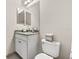 Cozy powder room with granite vanity top, white cabinets and tile floors at 30715 Tumbleberry St, Wesley Chapel, FL 33543