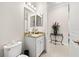 Bathroom featuring a toilet, vanity area with granite countertop, and a decorative table with floral arrangement at 30715 Tumbleberry St, Wesley Chapel, FL 33543