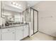 Bright bathroom vanity featuring a marble countertop, modern shower with black-framed glass door and double mirrors at 30715 Tumbleberry St, Wesley Chapel, FL 33543