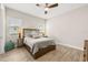 Bedroom with wood look flooring, ceiling fan, and two bedside lamps at 30715 Tumbleberry St, Wesley Chapel, FL 33543
