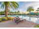 Resort-style community pool with palm trees, lounge chairs, and a waterslide, perfect for relaxation and recreation at 30715 Tumbleberry St, Wesley Chapel, FL 33543