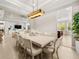 Elegant dining room with modern light fixture, open to the living room and kitchen areas at 30715 Tumbleberry St, Wesley Chapel, FL 33543