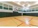 Indoor basketball court features a hardwood floor with colorful lines and a basketball hoop against a padded wall at 30715 Tumbleberry St, Wesley Chapel, FL 33543