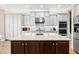Spacious kitchen featuring dark wood island with white countertop and stainless steel appliances at 30715 Tumbleberry St, Wesley Chapel, FL 33543