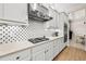 Modern kitchen features white cabinets, stainless steel appliances and hexagon patterned backsplash at 30715 Tumbleberry St, Wesley Chapel, FL 33543