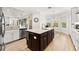 Kitchen with a dark island, white cabinets, and a stainless steel dishwasher at 30715 Tumbleberry St, Wesley Chapel, FL 33543