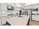 Large island in the kitchen with a stainless steel refrigerator and white cabinets at 30715 Tumbleberry St, Wesley Chapel, FL 33543