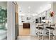 Open kitchen with island seating, white cabinets and stainless steel appliances at 30715 Tumbleberry St, Wesley Chapel, FL 33543