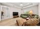Bright living room with hardwood floors and an olive-colored sofa under an elegant lighting fixture on the tray ceiling at 30715 Tumbleberry St, Wesley Chapel, FL 33543
