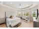 Bright main bedroom featuring tray ceilings, a comfy lounge area and ample windows at 30715 Tumbleberry St, Wesley Chapel, FL 33543