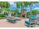 Inviting outdoor lounge area with comfortable seating and a stone fireplace, perfect for relaxing and entertaining at 30715 Tumbleberry St, Wesley Chapel, FL 33543