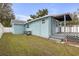 Light blue home featuring an enclosed back porch and a grassy backyard at 5161 Rena N St, St Petersburg, FL 33709