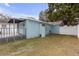 Light blue home featuring an enclosed back porch and grassy backyard with white fencing at 5161 Rena N St, St Petersburg, FL 33709