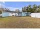 Backyard of the home with an outdoor shed, back porch, and white fencing at 5161 Rena N St, St Petersburg, FL 33709