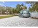Cozy light blue home featuring a welcoming front porch and a spacious paved driveway at 5161 Rena N St, St Petersburg, FL 33709