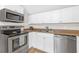 Compact kitchen with stainless steel appliances, light countertop and white cabinets at 5161 Rena N St, St Petersburg, FL 33709