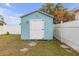 Light blue outdoor shed surrounded by a white fence and a grassy yard at 5161 Rena N St, St Petersburg, FL 33709