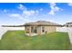 Large backyard featuring a covered patio and a white fence at 5403 Fez Ct, Brooksville, FL 34602