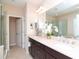 Elegant bathroom boasts double sinks, a large mirror, and a glass-enclosed shower for a luxurious feel at 11125 Winthrop Lake Dr, Riverview, FL 33578