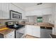 Bright kitchen features stainless steel appliances, granite countertops, and white cabinetry at 2375 Lake Heather Heights Ct # 202, Dunedin, FL 34698