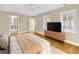 Bright bedroom featuring a ceiling fan, wood flooring, neutral walls, and a modern entertainment stand at 4845 W Sunset Blvd, Tampa, FL 33629