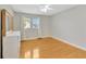 Bright bedroom featuring hardwood floors, windows with blinds and curtains, and a white dresser at 4845 W Sunset Blvd, Tampa, FL 33629