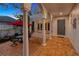 Inviting outdoor patio featuring brick flooring, arched columns, and comfortable seating area with red umbrella at 4845 W Sunset Blvd, Tampa, FL 33629