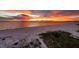 Panoramic aerial view of the beach showing the expansive shoreline, sunset, and cityscape at 7537 Bayshore Dr # 406, Treasure Island, FL 33706