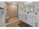Modern bathroom with a glass-enclosed shower, neutral tile, and a white vanity with double sinks at 7537 Bayshore Dr # 406, Treasure Island, FL 33706