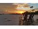 Beautiful sunset at the beach with lifeguard chairs, games, and gentle waves at 7537 Bayshore Dr # 406, Treasure Island, FL 33706