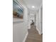 Bright hallway with wood floors leads to the bedroom and features a beach-themed art print at 7537 Bayshore Dr # 406, Treasure Island, FL 33706