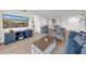 Comfortable living room with TV, console, two chairs and plenty of natural light at 7537 Bayshore Dr # 406, Treasure Island, FL 33706