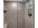 Shower with neutral tile, a glass door, and a built-in seat and shelf at 7537 Bayshore Dr # 406, Treasure Island, FL 33706