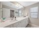 Well-lit bathroom with double sinks, white cabinetry, quartz countertops, and a large mirror at 14786 Horse Trot Rd, Lithia, FL 33547