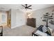 Comfortable bedroom with plush carpet, a ceiling fan and a decorative tree mural and furnishings at 14786 Horse Trot Rd, Lithia, FL 33547