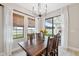 Bright dining room featuring rustic table, modern chandelier, and sliding glass door to backyard at 14786 Horse Trot Rd, Lithia, FL 33547