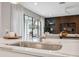 Close up on stainless steel kitchen sink with view to the modern living room at 14786 Horse Trot Rd, Lithia, FL 33547