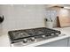 Modern gas cooktop with white tile backsplash and stainless steel accents at 14786 Horse Trot Rd, Lithia, FL 33547