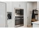 Built-in stainless steel microwave and oven in a modern white kitchen at 14786 Horse Trot Rd, Lithia, FL 33547