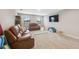 Spacious living room featuring neutral walls, plush carpeting, and comfortable brown leather furniture at 14786 Horse Trot Rd, Lithia, FL 33547