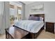 Bedroom with a wooden bed, bench, and doors leading to a private balcony at 200 Cordova Ne Blvd, St Petersburg, FL 33704