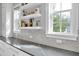 Modern kitchen featuring marble backsplash, countertops, and floating shelves by large windows at 200 Cordova Ne Blvd, St Petersburg, FL 33704
