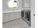 Laundry room featuring a round window, patterned floors, and stainless steel washer and dryer at 200 Cordova Ne Blvd, St Petersburg, FL 33704