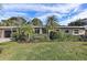 Charming single-story home with a lush, well-manicured front yard and tropical landscaping at 219 57Th S Ave, St Petersburg, FL 33705