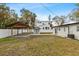 Backyard featuring a covered patio, lush lawn, white privacy fence, and AC unit at 4420 Pompano Se Dr, St Petersburg, FL 33705
