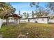 Expansive backyard with a covered patio, lush lawn, and privacy fence at 4420 Pompano Se Dr, St Petersburg, FL 33705